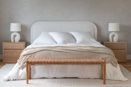 Family primary bedroom with white curved headboard layered linen  bedding and woven leather bench — fall home reset —  A Design Lifestyle