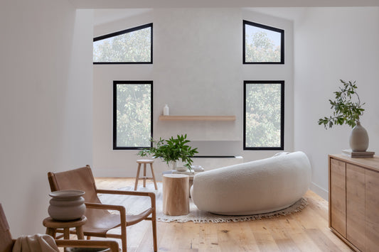 Boucle sofa and natural wood side table with garden views — family home summer design