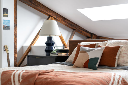 A cozy fall-styled bedroom vignette with warm textures and layered lighting